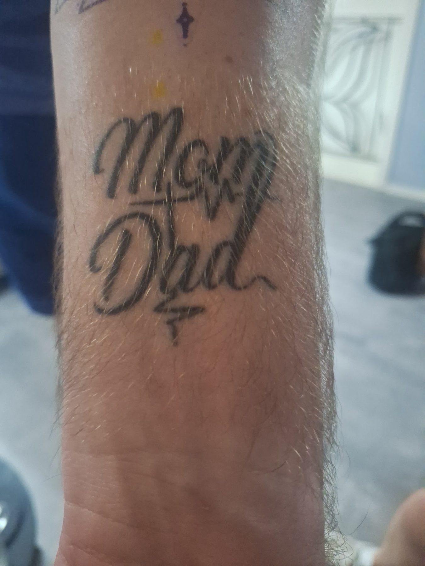 De woorden Mom en Dad in sierlijk schrift op een pols