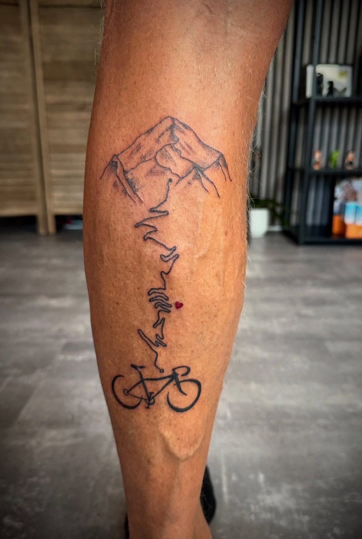 Bergtoppen, een hartslaglijn en een racefiets op een kuit